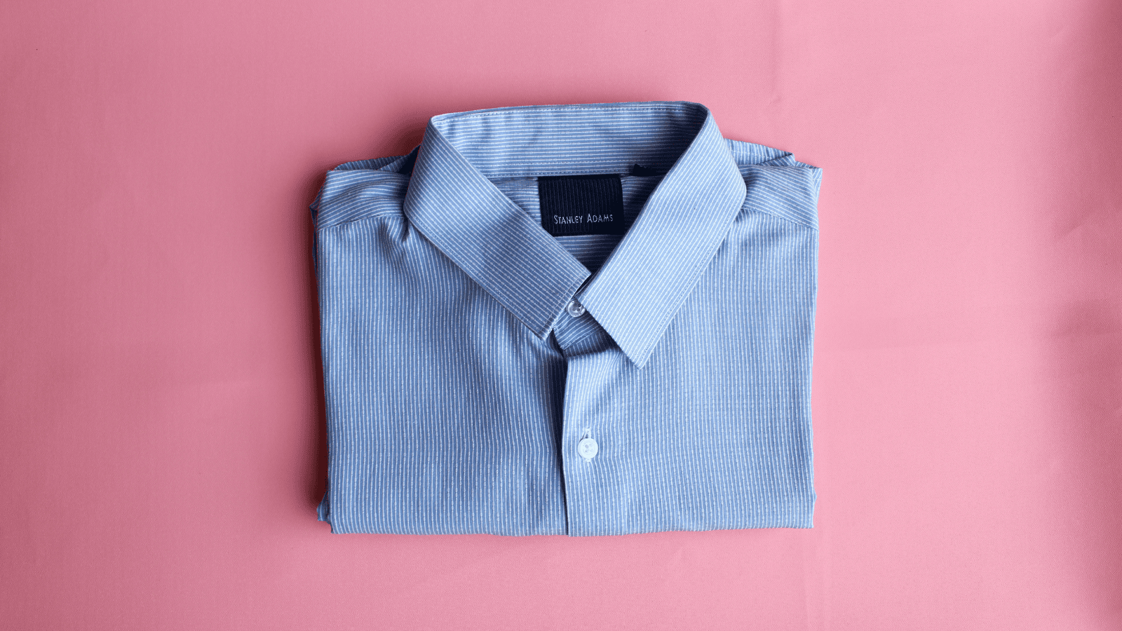 Freshly ironed blue dress shirt, neatly folded and ready to wear after our professional ironing service.
